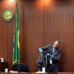 Snohomish County sheriffs detective Brad Walvatne shows jurors a shirt that Jesus Jesse Cardenas Lopez wore when he was stabbed to death in 2014, at Encarnacion Salas murder retrial Sept. 16 in Everett. (Caleb Hutton / The Herald)