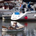 A pair of boaters watch the installation of the Grand Avenue Park Bridge as it is slowly rotated into place along Marine View Drive on Wednesday in Everett. (Andy Bronson / The Herald)