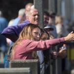 A woman explains to a friend how the bridge goes into place as they watch the installation from the marina pier while the Grand Avenue Park Bridge is slowly rotated into place along Marine View Drive on Wednesday in Everett. (Andy Bronson / The Herald)