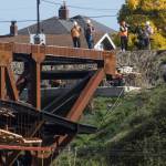 Crews watch as the east side of the Grand Avenue Park Bridge is lowered into place on Wednesday in Everett. (Andy Bronson / The Herald)