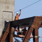 A worker waves to his mother as the Grand Avenue Park Bridge was lowered into place along Marine View Drive on Wednesday in Everett. (Andy Bronson / The Herald)