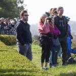 For a better view, some people watch from in front of the hedges at Grand Avenue Park on Wednesday in Everett. (Andy Bronson / The Herald)