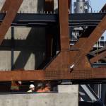 Workers watch from below as the $20 million Grand Avenue Park Bridge was slowly lowered into place above Marine View Drive on Wednesday, Sept. 25, 2019 in Everett, Wash. (Andy Bronson / The Herald)