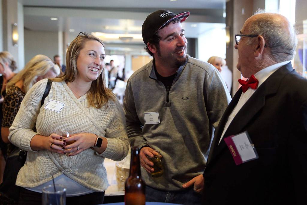 Krystal Madonia (left) and Devin Madonia talk with inductee Carl Zaretzke during the 10th Annual Snohomish County Sports Hall of Fame Banquet Wednesday evening at Angel of the Winds Arena in Everett. (Kevin Clark / The Herald)
