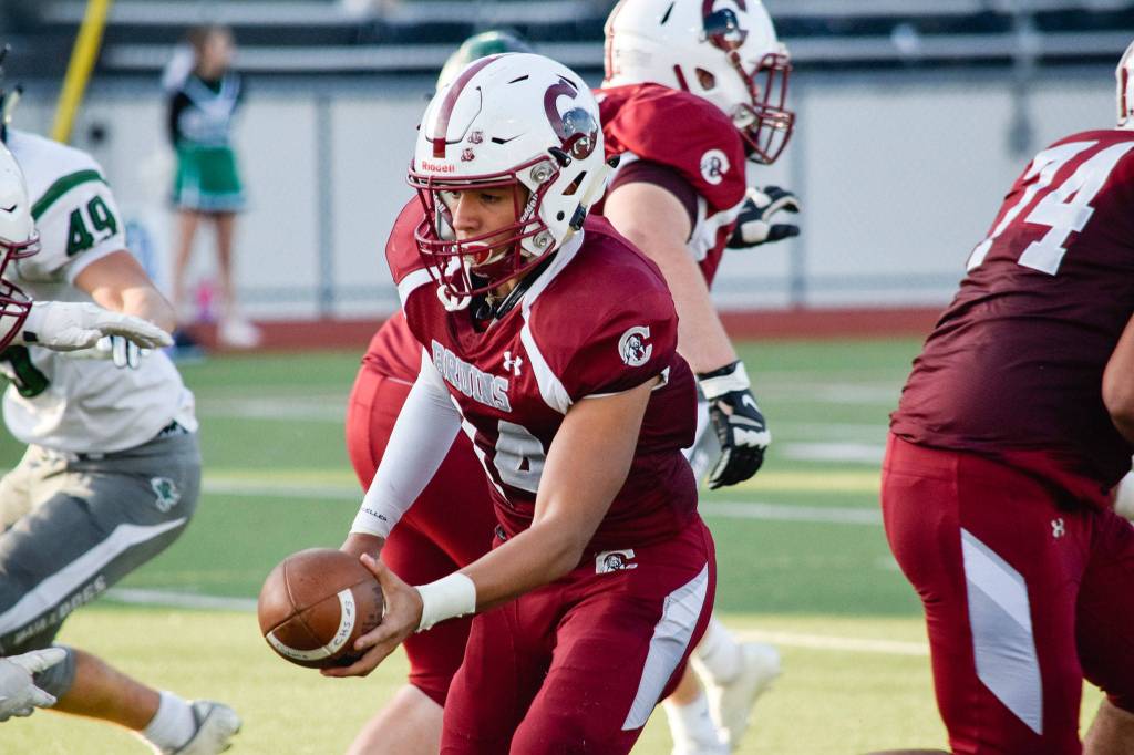 Junior quarterback Francisco Beltran hands the ball off against Mount Vernon on Friday, Sept. 20 at Everett Memorial Stadium. (Katie Webber / The Herald)