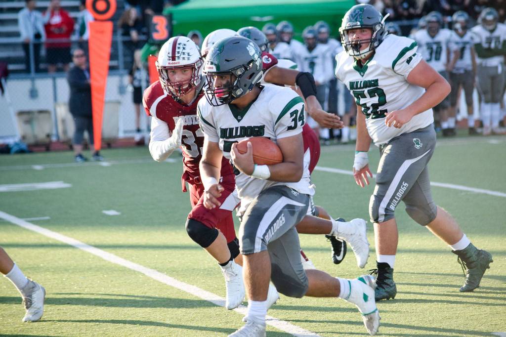 Junior running back Victor Martinez runs against the Cascade defense on Friday, Sept. 20 at Everett Memorial Stadium. (Katie Webber / The Herald)