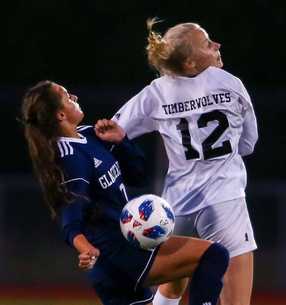 Glacier Peaks Addison Dizard (left) and Jacksons Kate Russell jump for control Tuesday night at Glacier Peak High School in Snohomish on September 24, 2019. Glacier Peak won 5-1. (Kevin Clark / The Herald)