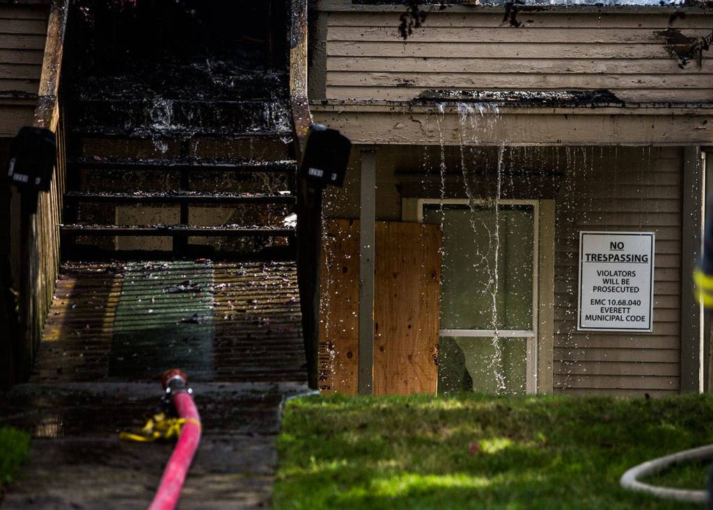 Water pours out of a home that caught fire near Lombard Ave and 32nd Street on Thursday in Everett. (Olivia Vanni / The Herald)