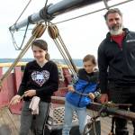 Captain Jamie Trost helps fourth-graders Jemma Kuku (left) and Braedon Lubach (center) learn the ropes before setting sail aboard the of the Lady Washington historic tall ship in Langley harbor. (Wendy Leigh / South Whidbey Record)