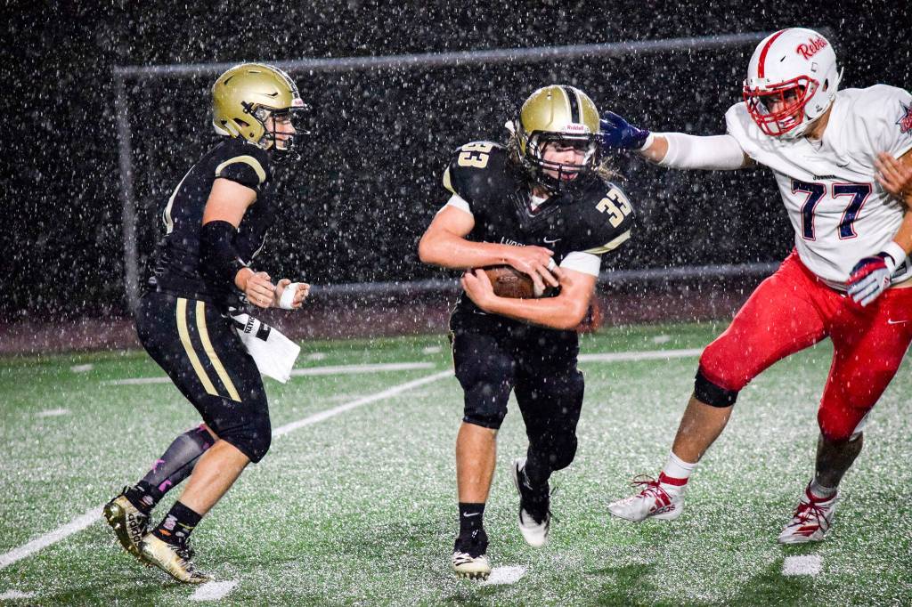 Lynnwood sophomore tight end Zach Newson runs past Juanitas defensive lineman Joseph Poulin on Friday, Sept. 27 at Edmonds Stadium. (Katie Webber / The Herald)