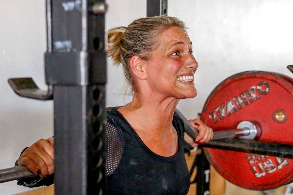 Colleen Hansford does a set of squats during a Sept. 24 workout at EGO Strength and Performance in Everett. (Kevin Clark / The Herald)
