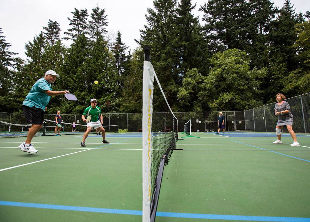 Roger BelAir plays doubles at Yost Park in Edmonds. (Olivia Vanni / The Herald)