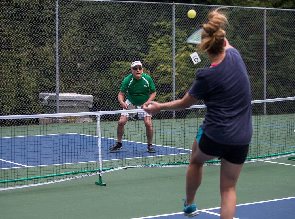 Roger BelAir prepares to hit the ball during a game of pickleball at Yost Park in Edmonds. (Olivia Vanni / The Herald)