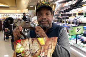 Albert Mojo Muldrow carries a fruit and veggie bag to an Everett store. (Janice Podsada / The Herald)