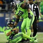 Seattles Mike Iupati helps Seahawks Russell Wilson to his feet after a tackle in the backfield during the Seahawks 30-29 win over the L.A. Rams on Thursday at CenturyLink Field in Seattle. (Kevin Clark / The Herald)