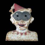 This heavy 20-inch-tall head is made of iron. It was painted red and white. The auction catalog said it was a clown because of the pointed hat with a tassel. Its a not-very-funny shooting gallery target that pictures a clown with a mask. It was made in America and used around 1911. The strange item was wanted by many collectors, and the high bid was $12,000. (Cowles Syndicate)