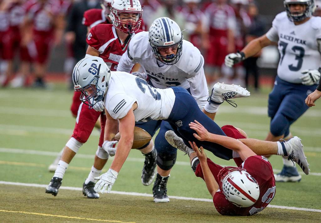 Glacier Peaks Dylan Owen crosses the goal line for a touchdown as the ball is stripped from his arms. Glacier Peak took on Cascade in football at Everett Memorial Stadium on Friday, Oct. 4, 2019 in Everett, Wash. (Andy Bronson / The Herald)