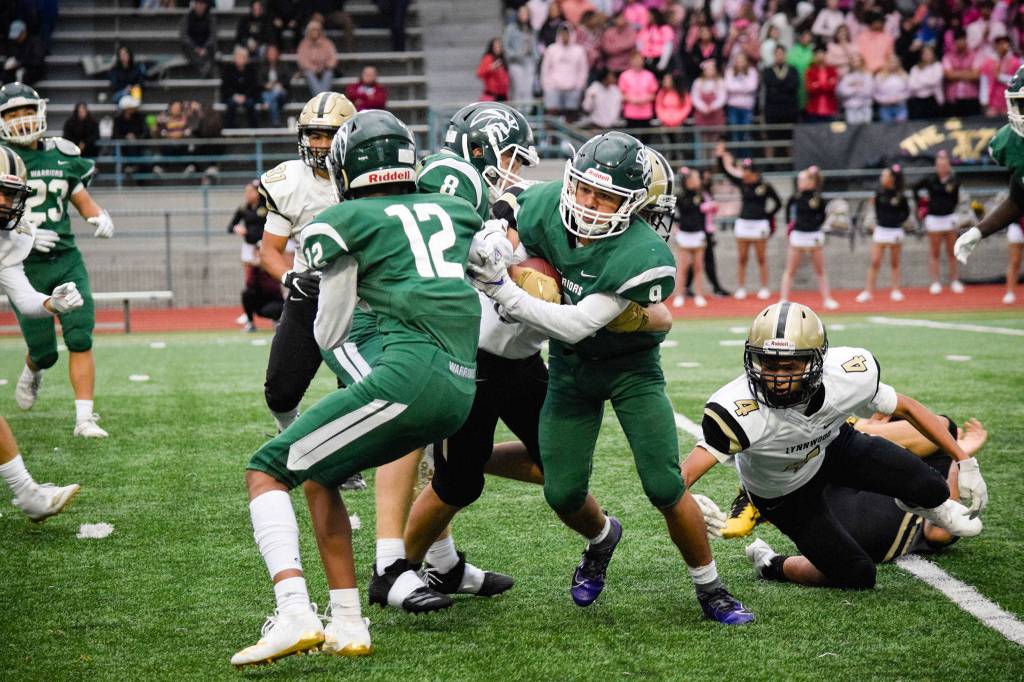 Junior running back Steele Swinton gets wrapped up by the Lynnwood defense on Friday at Edmonds Stadium. (Katie Webber / The Herald)