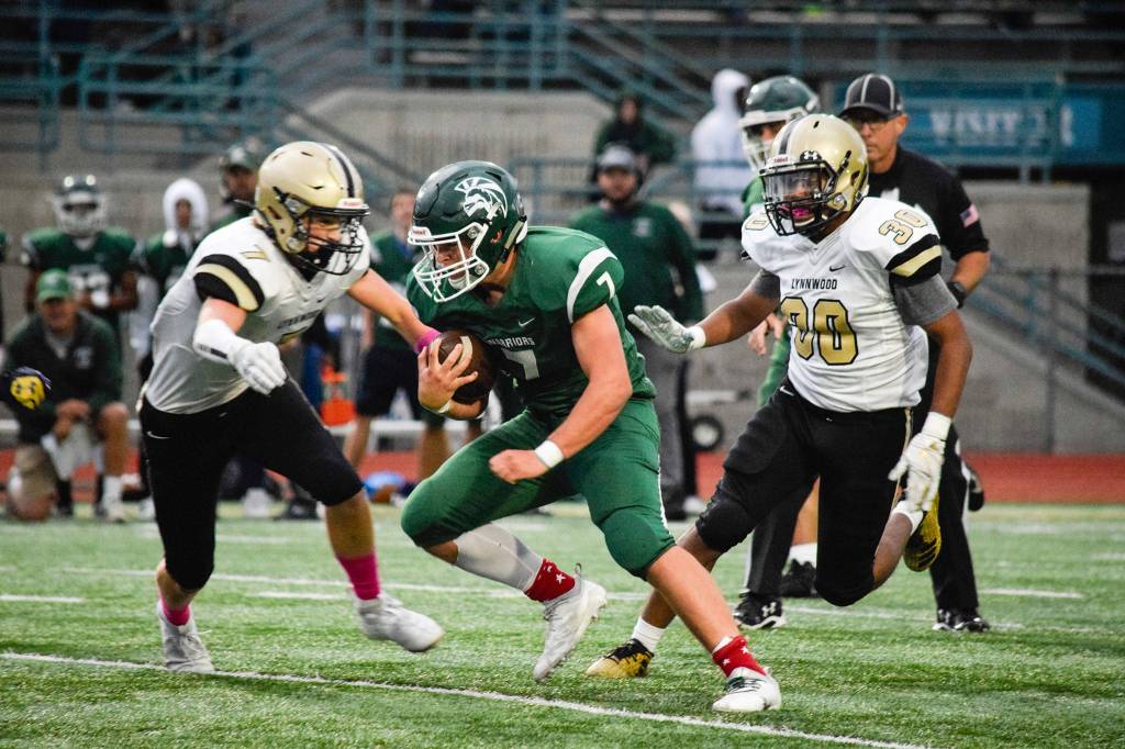 Senior running back Ben Grimes runs for a first down against Lynnwood on Friday at Edmonds Stadium. (Katie Webber / The Herald)