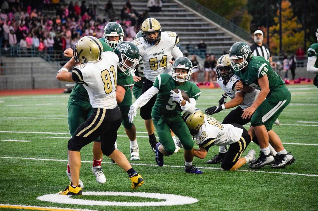 Junior running back Steele Swinton runs through the Lynnwood defense on Friday at Edmonds Stadium. (Katie Webber / The Herald)