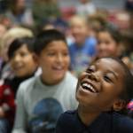 Florida Bernard, a third-grader, laughs at a joke made by Jake Shimabukuro, a renowned ukulele player, as he performs at Frank Wagner Elementary on Monday in Monroe. (Andy Bronson / The Herald)