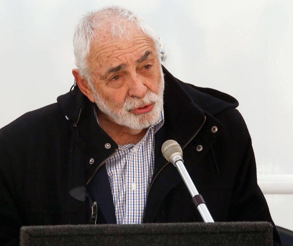 Dr. Larry Schecter, associate dean of clinical education-Everett with WSUs Elson S. Floyd College of Medicine, speaks to a crowd gathered in Everett to see the new Range Health mobile medical unit. (Dan Bates / The Herald)
