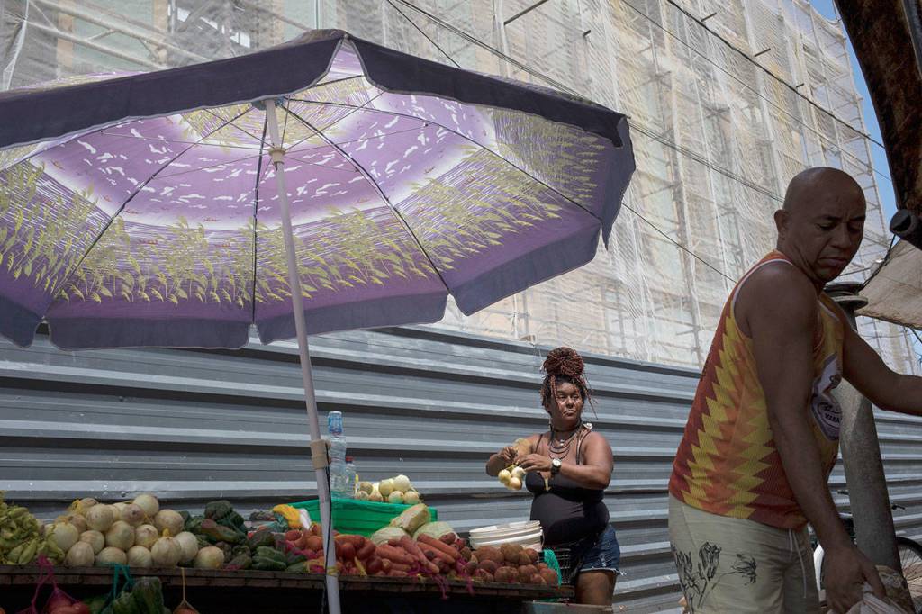 Vegetable vendors prepare their produce at the Ver-o-Peso riverside market in Belém, Brazil. Other vendors break the outer shells of Brazil nuts with sharp machetes or offer salted codfish, straw hats and fresh fruit like the bright red pupunha and the cupuacu that comes from the cacao plant family. (AP Photo/Rodrigo Abd)