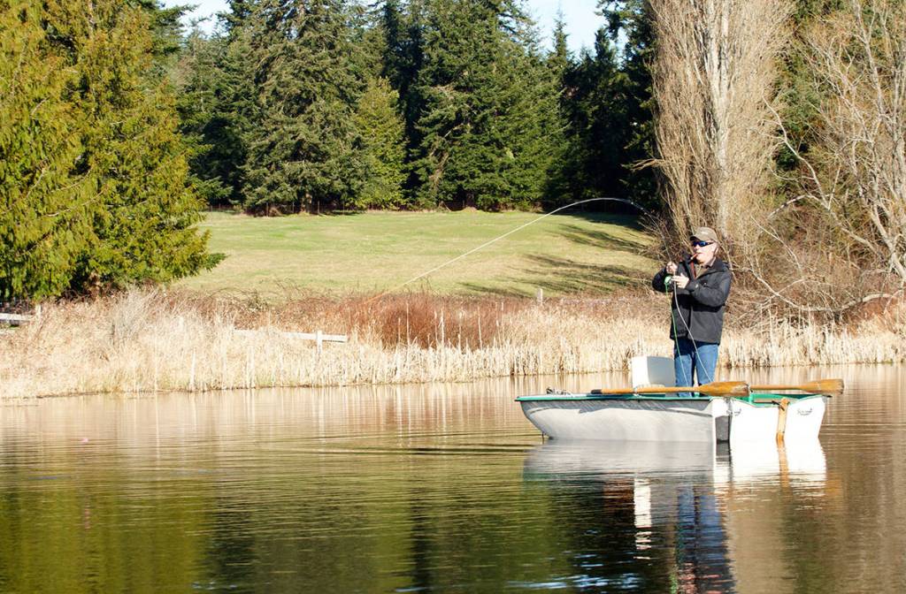 Dale Dennis of Arlington plays a trout on Lone Lake that grabbed his fly. (Mike Benbow photo)