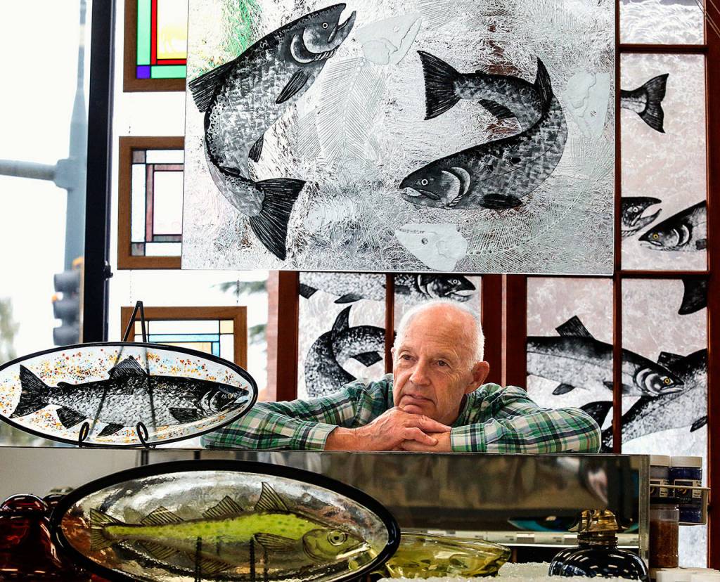 Fish are a common theme in the work of glass artist Stan Price, shown here in Covenant Art Glass. He and his wife, Colleen Price have operated their Everett business since 1979 but are planning to retire by years end. (Dan Bates / The Herald)Dan Bates / The Herald
