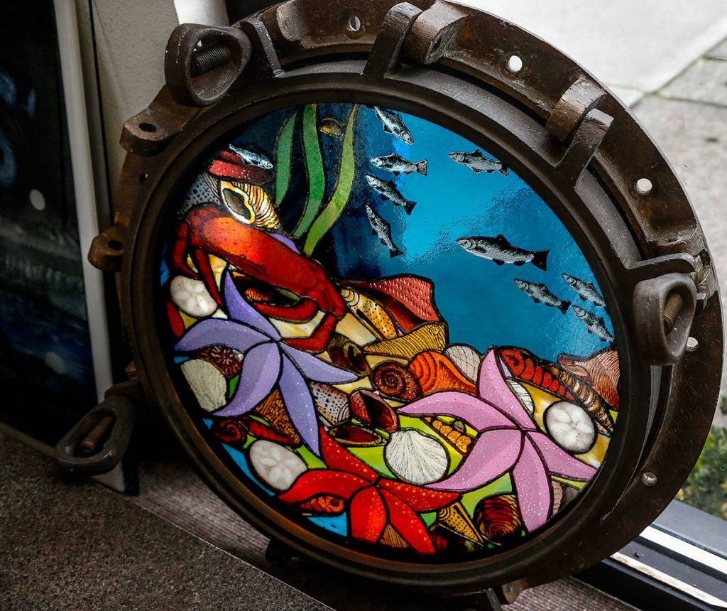 Among the Stan Price items to be sold at Covenant Art Glass next month will be this solid brass porthole in which Stan created a cheerful glass seascape. (Dan Bates / The Herald)