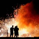 In a large area reserved for setting off fireworks in Tulalip, a trio of enthusiasts watch a shower of sparks June 26, 2018, as darkness falls at Boom City, the seasonal retail area on the Tulalip Indian Reservation. The Snohomish County Council wants to know how voters feel about a proposed fireworks use ban in unincorporated areas of Snohomish County, which would exclude Tulalip. (Dan Bates / The Herald)