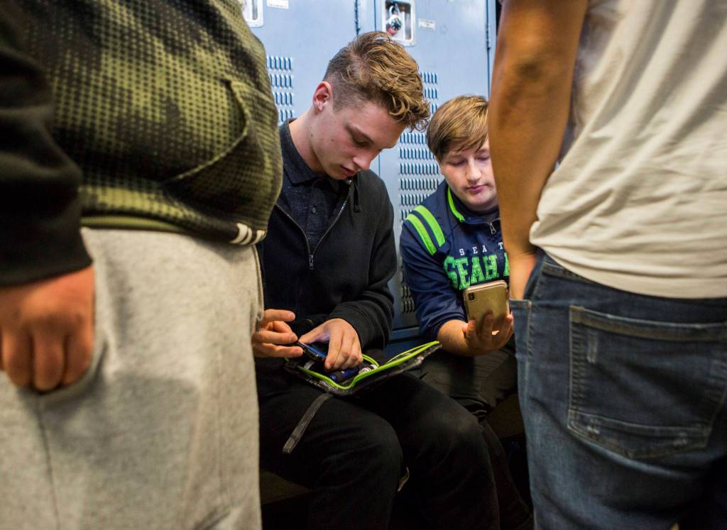 Mariner High Schools Jackson Cole checks his blood sugar in the locker room before the teams Oct. 17 football practice at Goddard Stadium in Everett. Cole was diagnosed with Type 1 diabetes at the the age of 2, but has never let it deter him from living his best life. (Olivia Vanni / The Herald)