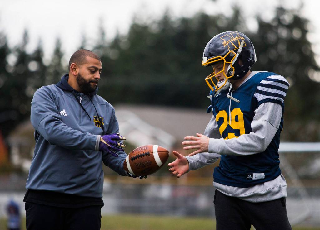 Mariner High Schools Jackson Cole (right) talks with Marauders quarterbacks coach Tony Young (left) during the teams Oct. 17 practice at Goddard Stadium in Everett. (Olivia Vanni / The Herald)