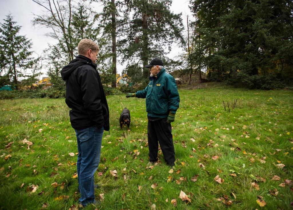 Jim Corcoran (right) talks to Ken Klein from the Snohomish County Executives Office about a small baseball field on his land near Mill Creek. (Olivia Vanni / The Herald)