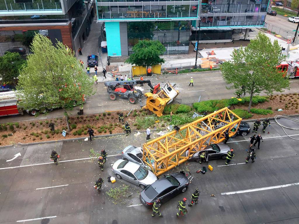 Fire and police work to clear the scene where a construction crane fell from a building on Googles new Seattle campus crashing down onto one of the citys busiest streets and killing multiple people on April 27. (AP Photo/Frank Kuin, file)