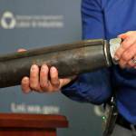 Brian Haight, Crane Program manager for Washington states Department of Labor and Industries, holds a 26-pound pin and sleeve of the type used in the collapse of a crane earlier in the year in Seattle that killed four people. Washington States L&I found, as experts have long suspected, that the crane toppled because workers who were disassembling it had prematurely removed pins securing the sections of the cranes mast. (AP Photo/Elaine Thompson)