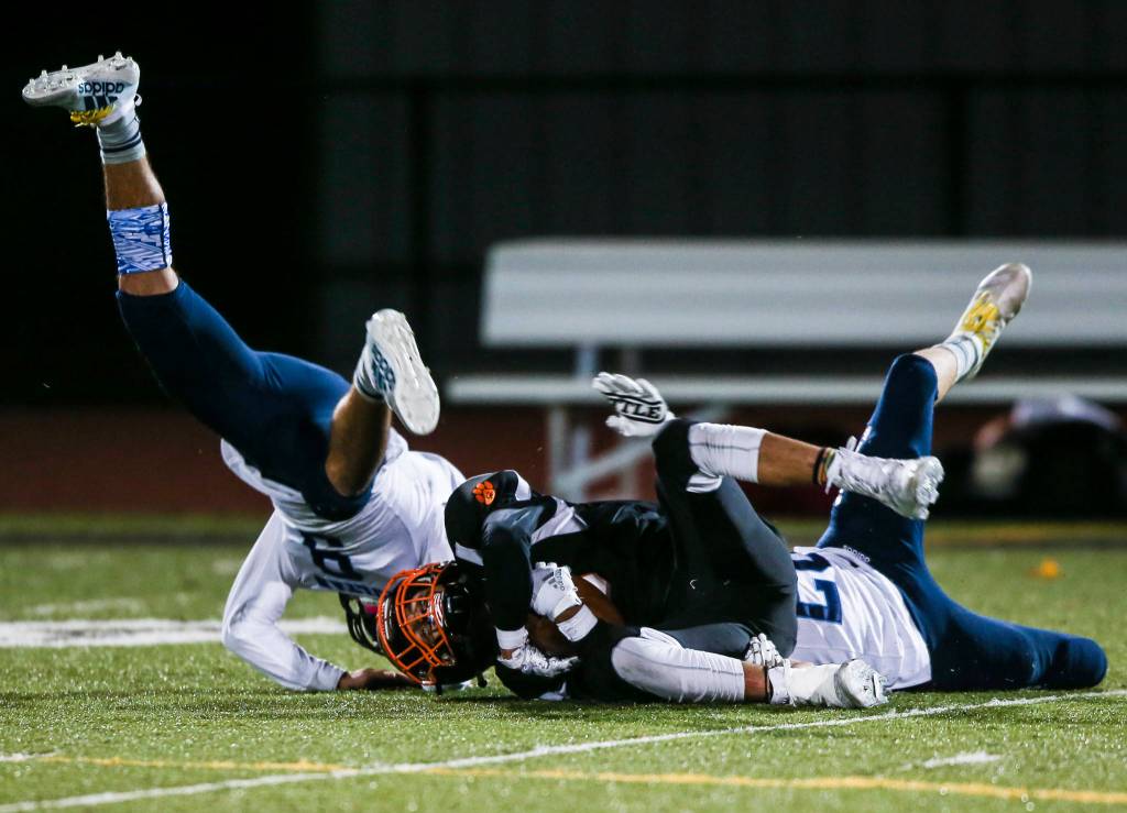 Two Sultan players collide while tackling Granite Falls Mason McBride during the game on Friday in Granite Falls. (Olivia Vanni / The Herald)