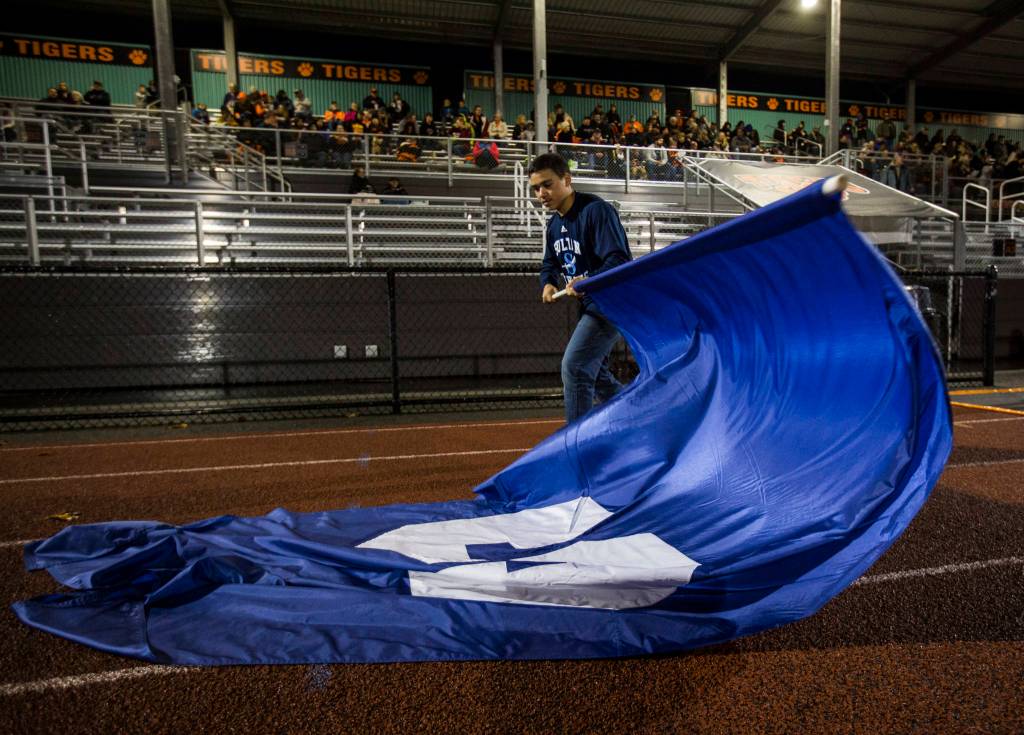 A student folds up the Sultan High School flag during a game against Granite Falls on Friday in Granite Falls. (Olivia Vanni / The Herald)