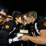 Granite Falls Mason McBride (left) and Blake Williams kiss the Black & Blue Bowl trophy after beating Sultan 45-0 on Friday in Granite Falls. (Olivia Vanni / The Herald)