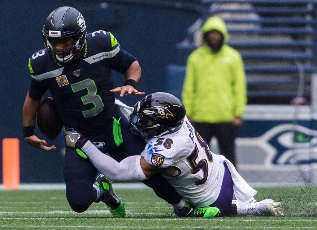 Seattle Seahawks Russell Wilson loses control of the ball after being tackled by Baltimore Ravens L.J. Fort during the game against the Baltimore Ravens on Sunday, Oct. 20, 2019 in Seattle, Wash. (Olivia Vanni / The Herald)