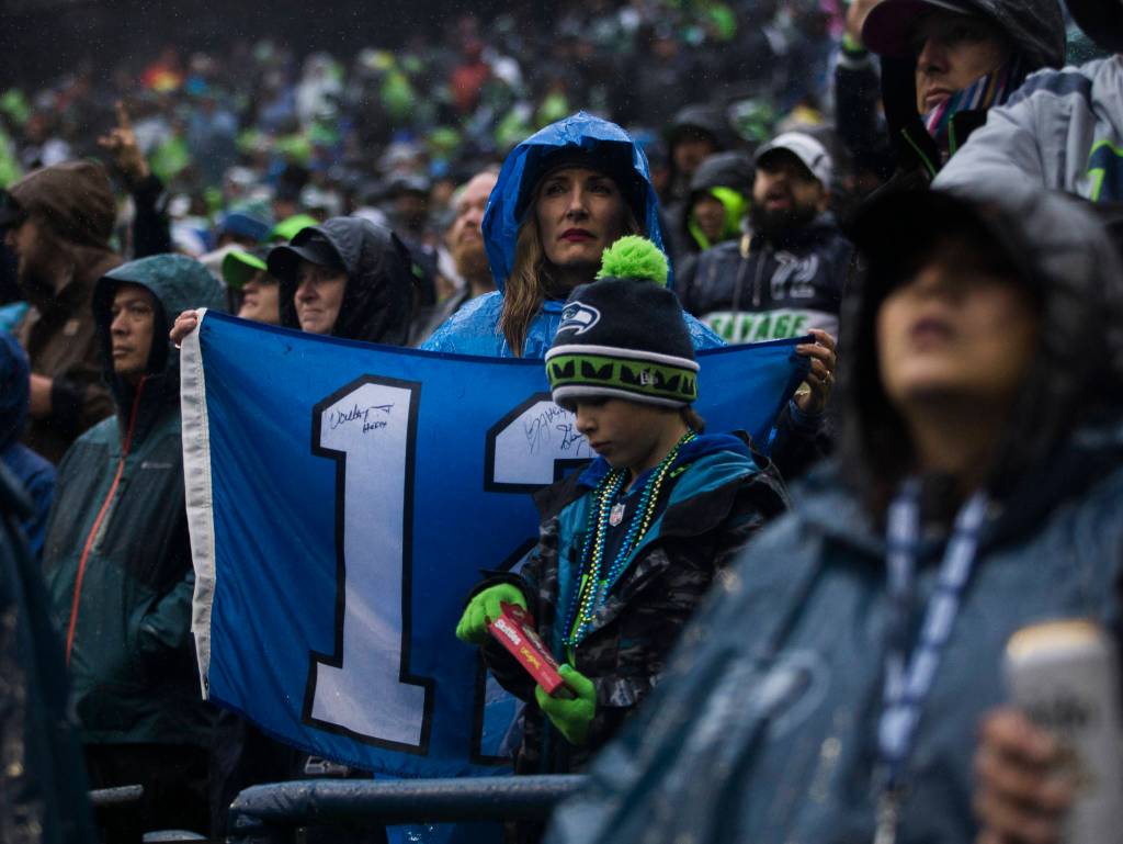 A Seahawks fan holds up a wet Twelfth Man flag during the game against the Baltimore Ravens on Sunday, Oct. 20, 2019 in Seattle, Wash. (Olivia Vanni / The Herald)