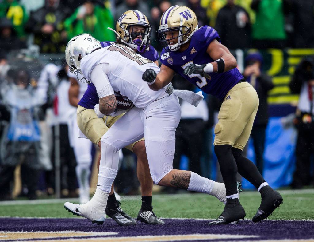 Oregon Ducks quarterback Justin Herbert runs between two Husky players for a touchdown during the game against Oregon on Saturday, Oct. 19, 2019 in Seattle, Wash. (Olivia Vanni / The Herald)