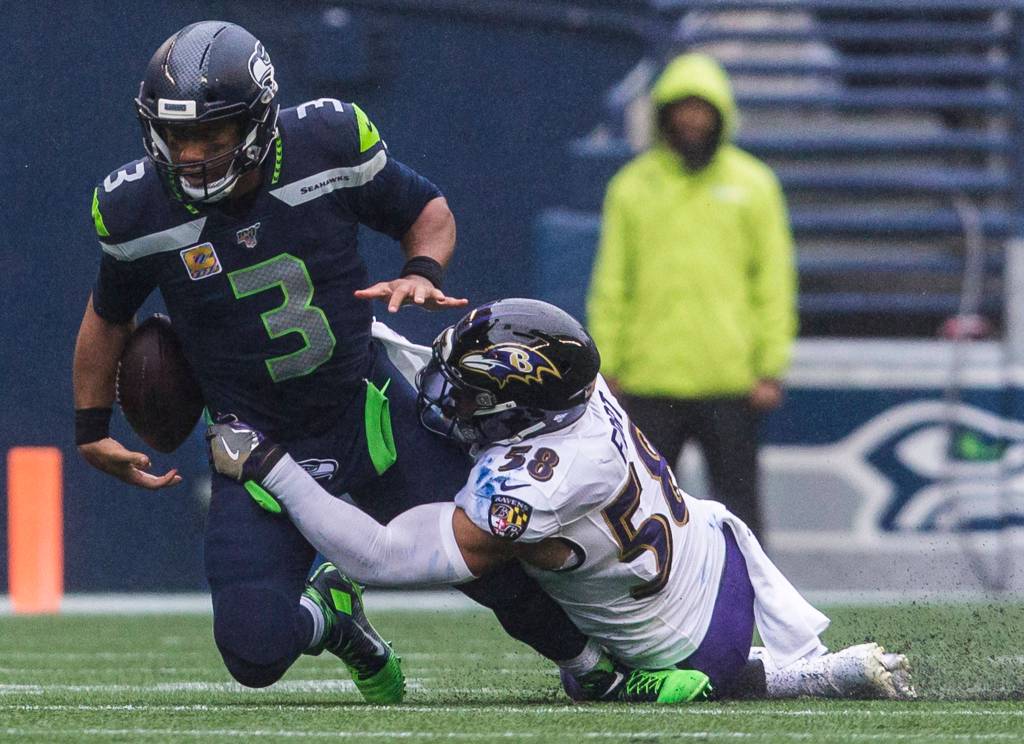 Seattle Seahawks Russell Wilson loses control of the ball after being tackled by Baltimore Ravens L.J. Fort during the game against the Baltimore Ravens on Sunday, Oct. 20, 2019 in Seattle, Wash. (Olivia Vanni / The Herald)