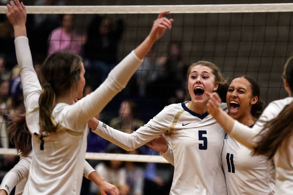 Arlington celebrates a point against Oak Harbor Thursday evening at Arlington High School on October 24, 2019. Arlington won in straight sets. (Kevin Clark / The Herald)