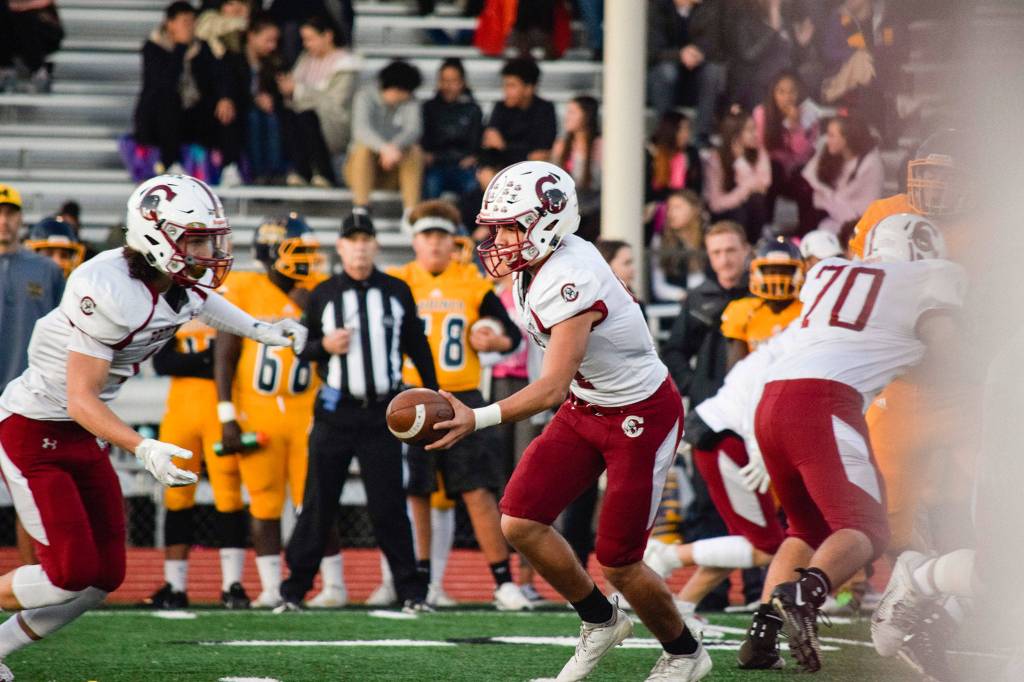 Junior quarterback Francisco Beltran hands-off the ball to junior running back Michael Purl against Mariner on Friday, Oct. 25 at Goddard Stadium in Everett. (Katie Webber / The Herald)