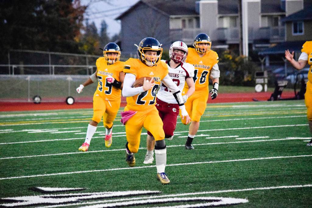 Junior quarterback Jackson Cole runs for a first down against Cascade on Friday, Oct. 25 at Goddard Stadium in Everett. (Katie Webber / The Herald)