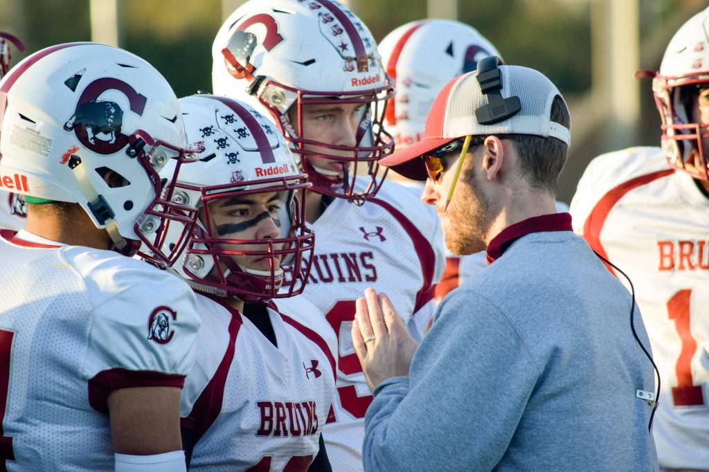 Cascade head coach Jordan Sieh talks to senior Edgar Rendiz and his teammates in-between plays against Mariner on Friday, Oct. 25 at Goddard Stadium in Everett. (Katie Webber / The Herald)