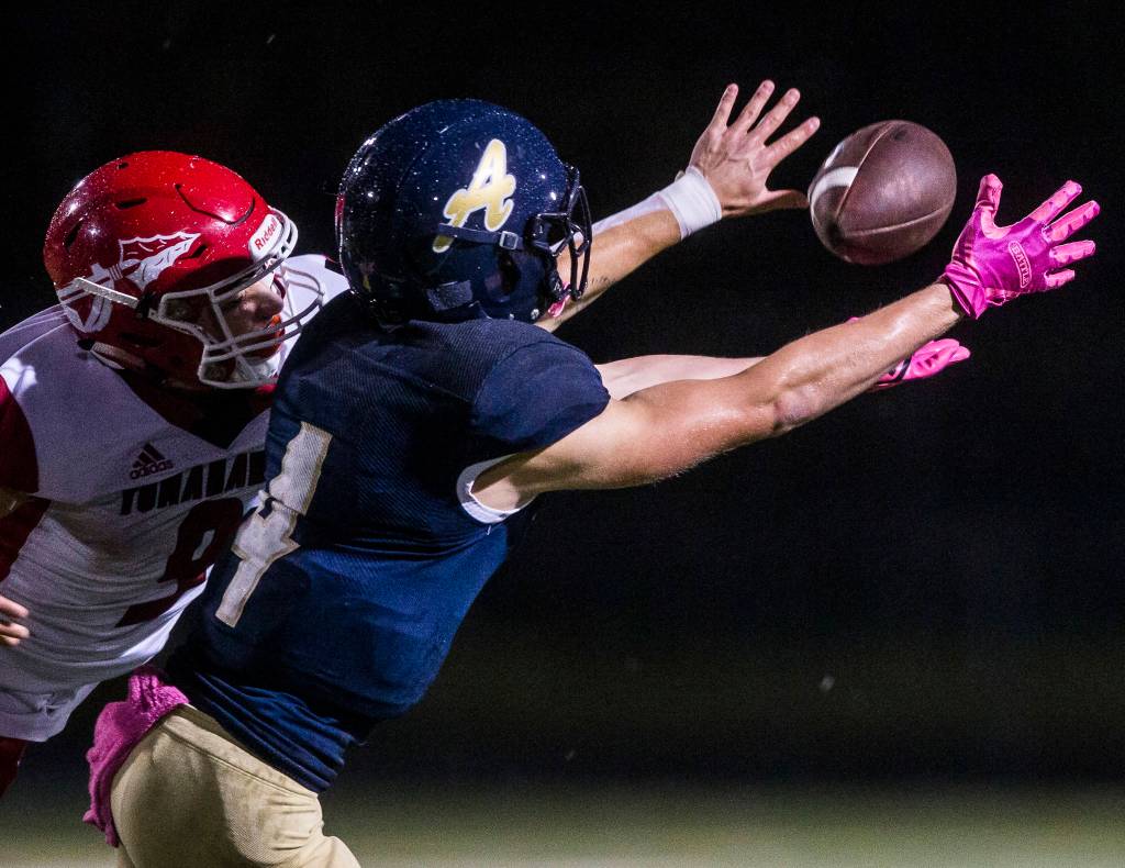 Marysville Pilchucks Jordan Justice (left) deflects a pass away from Arlingtons Joseph Schmidt during a Wesco 3A North game on Friday at John C. Larson Stadium in Arlington. Marysville Pilchuck beat Arlington 42-14 to win the Wesco 3A North title. (Olivia Vanni / The Herald)