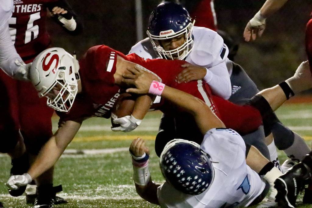 Snohomishs Tyler Larson stretches for extra yards with Meadowdales defense Friday evening at Veterans Memorial Stadium in Snohomish on October 25, 2019. (Kevin Clark / The Herald)