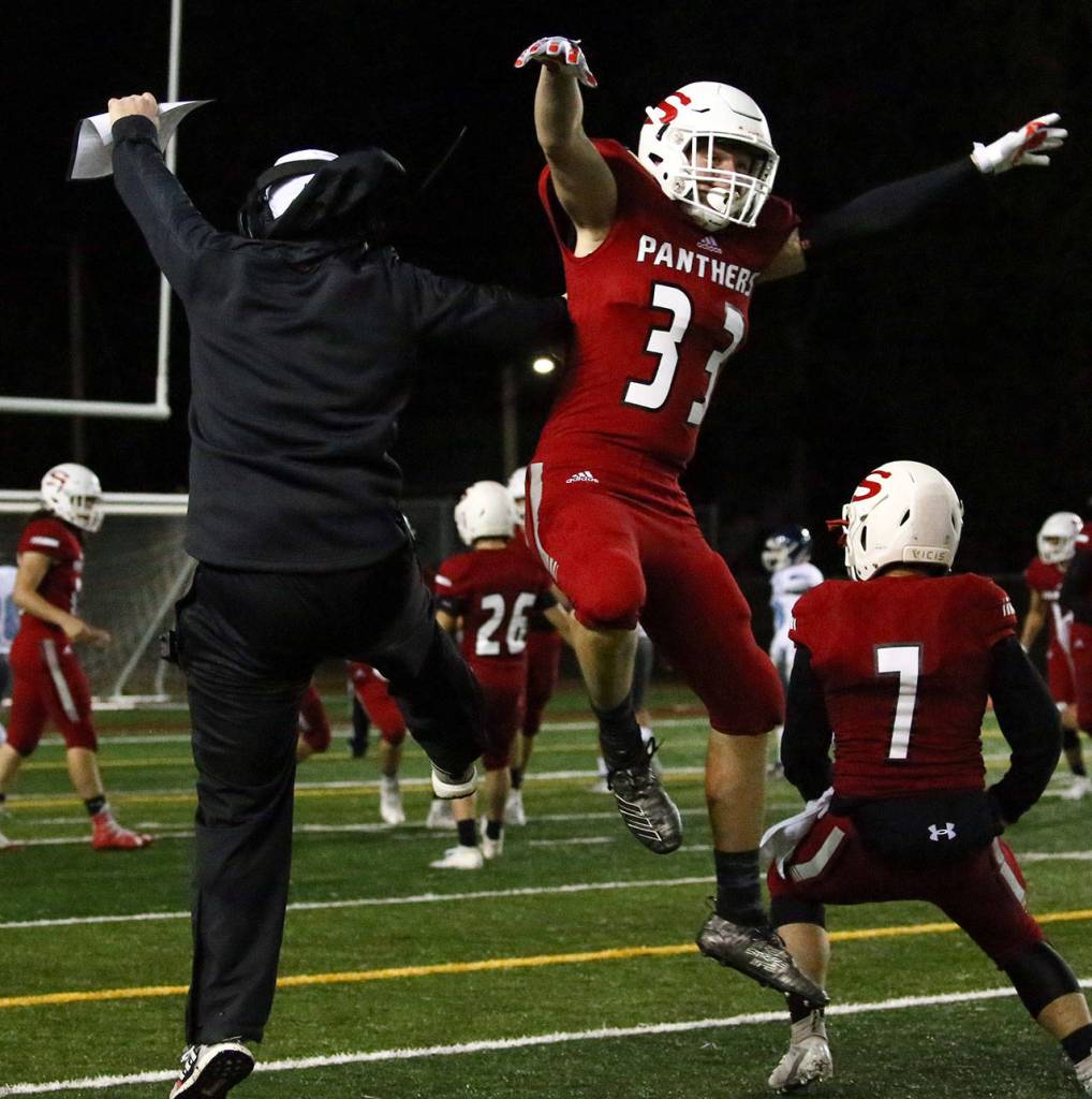 Snohomishs head coach Joey Hammer (left) celebrates with Owen Kaestner Friday evening at Veterans Memorial Stadium in Snohomish on October 25, 2019. (Kevin Clark / The Herald)